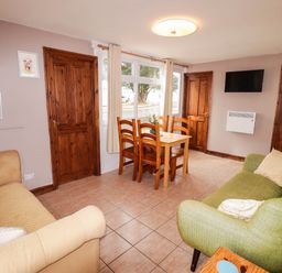 A living room with a table and chairs at Chalet 242 Carmarthen Bay in Kidwelly