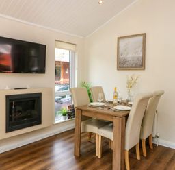 A dining room with a table set for dinner at Fir Tree Lodge Coniston 3, White Cross Bay near Windermere
