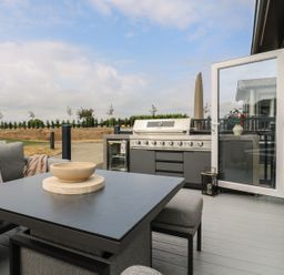 An outdoor patio with seating and a grill at Lakewood Plot 7 Clacton-on-Sea