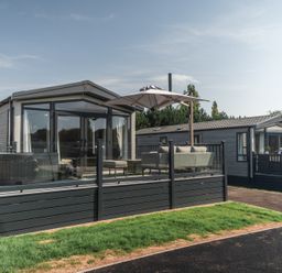 A mobile home with a deck and furniture at Lakewood Plot 7 St. Osyth