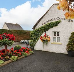 A garden with flowers and a cottage at Teresa's Cottage