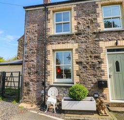 An exterior view of a house with a stone wall and a planter at 11 Church Street, Narberth