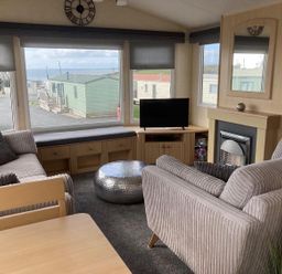 A living room with a sofa and television at Beautifully Presented 2 Bedroom Static Caravan in Monreith near Whithorn