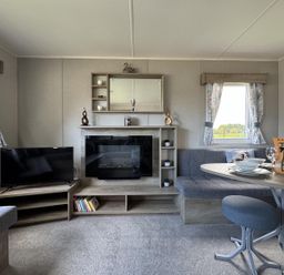 A living room with a sofa and television at West Lawn 47 Haggerston Castle Paddock Views Haggerston