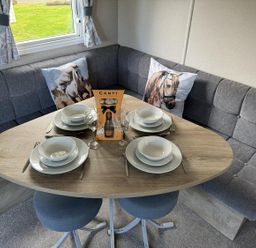 A dining area with a table set for four at West Lawn 47 Haggerston Castle Paddock Views Haggerston