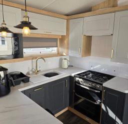 A kitchen with appliances and cabinetry at 3 Bed-Sleeps 8-Free Parking-5 Min to Beach in Embo near Dornoch