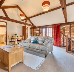 A living room with a sofa and coffee table at Barn Conversion Sleeps 2 with Parking in Diss