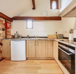 A kitchen with cabinets, sink, and appliances at Barn Conversion Sleeps 2 with Parking in Diss