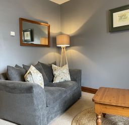 A living room with a sofa, lamp, and coffee table at Milecastle Inn on Hadrian's Wall near Haltwhistle