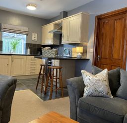 A kitchen area with bar stools and couches at Milecastle Inn on Hadrian's Wall near Haltwhistle