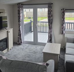 A living room with a television and fireplace at 3 Bedroom Cabin Sleeps 6 - Shared Pool & Shared Hot Tub, Flamingo Land Resort near Malton