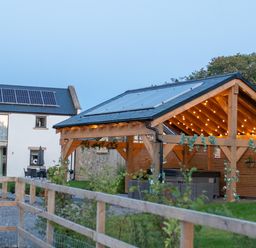 An outdoor area with a house and shelter featuring solar panels at Northumberland Luxury Stays - The Chivits West Chevington near Amble