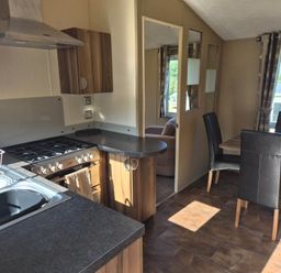 A kitchen with appliances and dining area at Cabin - Sleeps 6 - Outdoor Pool and Parking in Cenarth