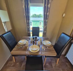 A dining room with a table set for meals at Cabin - Sleeps 6 - Outdoor Pool and Parking, Cenarth