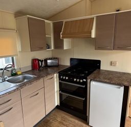 A kitchen with a sink and refrigerator at Seaside Tranquility Retreat in Clacton