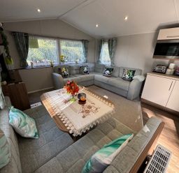 A living room with a seating area and a table at Wl34 Caravan Haggerston Castle Private Decking Haggerston