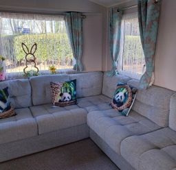 A living room with a sofa and cushions at Wl34 Caravan Haggerston Castle Private Decking Haggerston