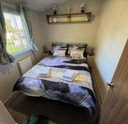 A bedroom with a bed and shelf at Wl34 Caravan Haggerston Castle Private Decking Haggerston