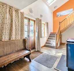 A hallway with a wooden bench and staircase at 3-Bed Barn Eco-Lodge on the Tarka trail East Yarde near Great Torrington