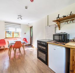 A kitchen with a table and chairs at 3-Bed Barn Eco-Lodge on the Tarka trail East Yarde near Great Torrington