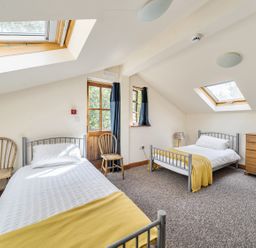 A bedroom with two beds and a wooden dresser at 3-Bed Barn Eco-Lodge on the Tarka trail East Yarde near Great Torrington