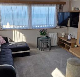 A living room with a sofa, coffee table, and TV at Seafront Caravan - Golden Sands - 6 Berth by Your Away Stays in Kinmel Bay
