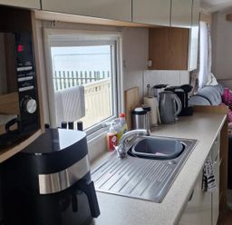 A kitchen with a sink and appliances at Seafront Caravan - Golden Sands - 6 Berth by Your Away Stays Kinmel Bay