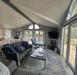 A living room with a sofa and coffee table at Holly Blue - Cosy wooden lodge, Kippford