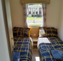 A bedroom with two beds and a window at Ye Old'e Man - Sleeps 6 & Pet Friendly Near Flookburgh