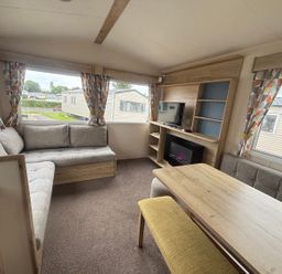 A living room with a sofa and table at Caravan Sleeps 5 - Decking, Parking, Pet Friendly in Blackpool