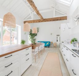 A kitchen with an island and dining setup at Simple Coastal Luxury near Southwold