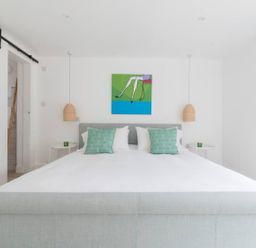 A bedroom with a bed and wall art at Simple Coastal Luxury near Southwold