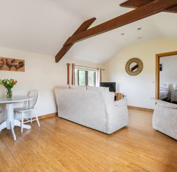A living room with a sofa, table, and television at The Shippon, Breathtaking Views, Private Hot Tub Winkleigh