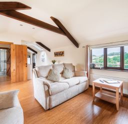 A living room with a sofa and side table at The Shippon, Breathtaking Views, Private Hot Tub in Winkleigh