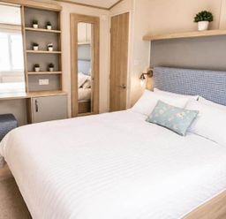 A bedroom with a bed and storage unit at Tattershall Lakes - Hot Tub - Sleeps 6 - Pets Tattershall