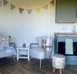 A kitchen with chairs and a table at Peaceful Shepherd Hut near Clovelly