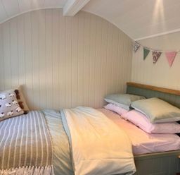 A bedroom with a bed and decorative bunting at Peaceful Shepherd Hut near Clovelly