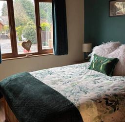 A bedroom with a bed and window at Cabin Sleeps 4 with Hot Tub and Parking near Wilberfoss