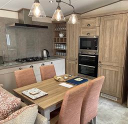 A kitchen with a dining area and modern appliances at The Old Barn in Manchester