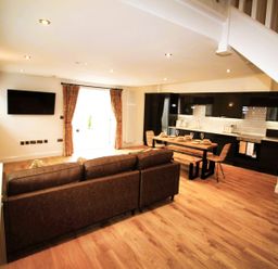 A living room and kitchen area with a sofa and dining table at Newly Refurbished Cottage, sleeping 4 and Central, Berwick-Upon-Tweed