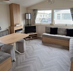 A living room with a sofa, coffee table, and television at Golden Sands 3-Bed Caravan, Parking and Pet Friendly, Towyn