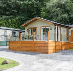 A log cabin with a deck and furniture at 19 Pony Meadow White Cross Bay near Troutbeck Bridge