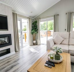 A living room with a sofa and television at 19 Pony Meadow near White Cross Bay