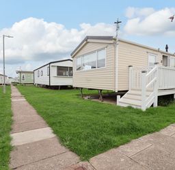 An outdoor area with mobile homes and a pathway at B54