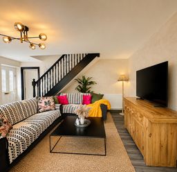 A living room with a sofa and coffee table at Muddy Boots – La Petite Mews in Kirby Stephen