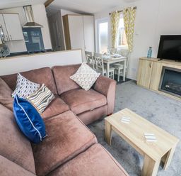A living room with a sofa and dining area at Seascape in Haverfordwest