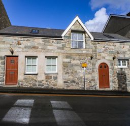 A stone house with front doors and windows at 2 bed Criccieth