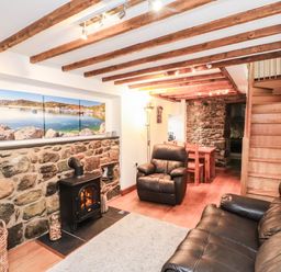 A living room with a sofa and armchair at 2 bed Criccieth
