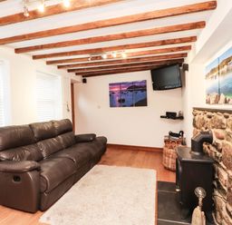 A living room with a sofa and television at 2 bed Criccieth