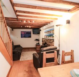 A living room with sofa and television at 2 bed Criccieth